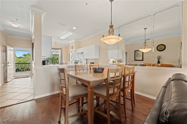 dining space with light hardwood / wood-style floors and ornamental molding