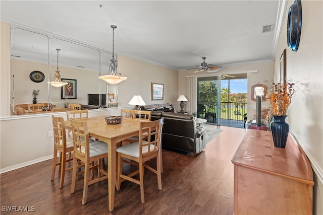 dining room featuring ceiling fan, ornamental molding, and dark wood-type flooring