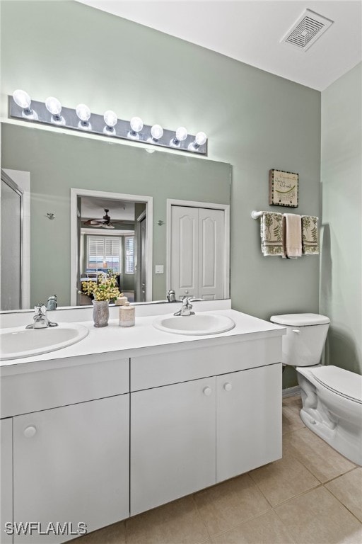 bathroom with vanity, a shower with door, tile patterned floors, ceiling fan, and toilet