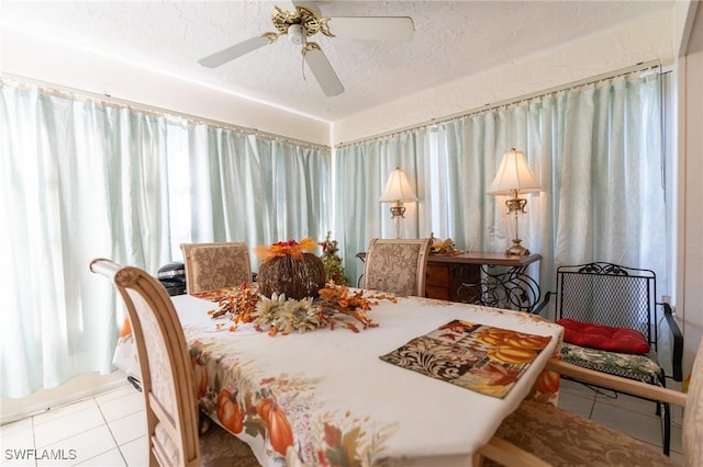 dining space with ceiling fan, light tile patterned floors, and a textured ceiling