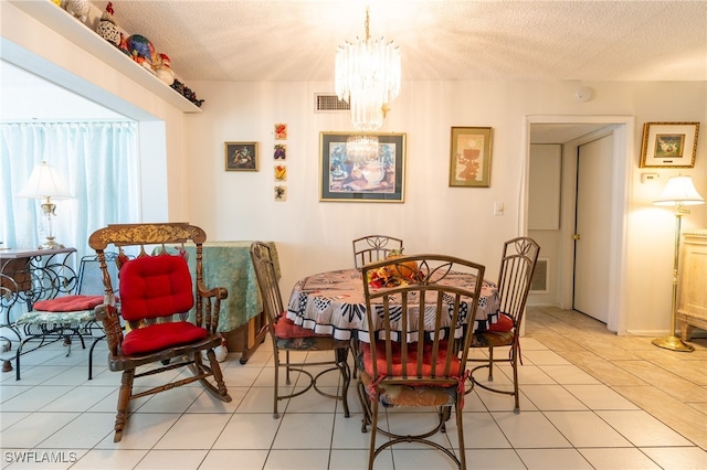 dining space with light tile patterned floors, a textured ceiling, and an inviting chandelier