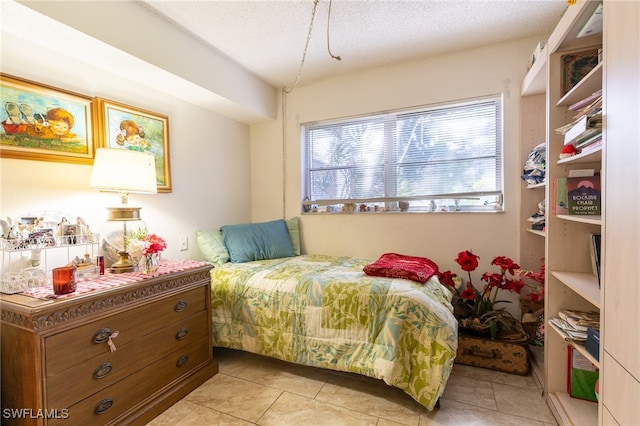 bedroom featuring light tile patterned floors and a textured ceiling