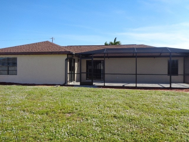 back of property featuring a patio area, a lanai, and a yard