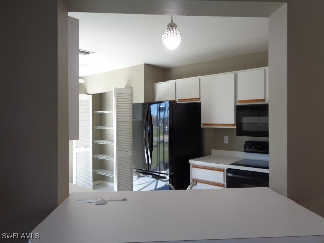 kitchen with white cabinets, pendant lighting, kitchen peninsula, and black appliances