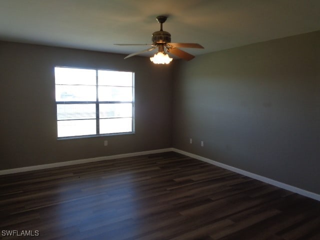 spare room with ceiling fan and dark wood-type flooring