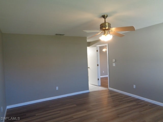 empty room with ceiling fan and dark wood-type flooring