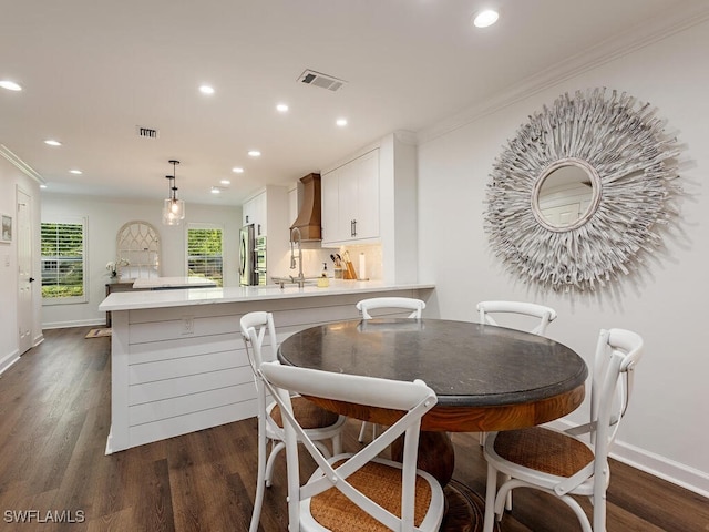 dining room featuring dark hardwood / wood-style flooring and crown molding