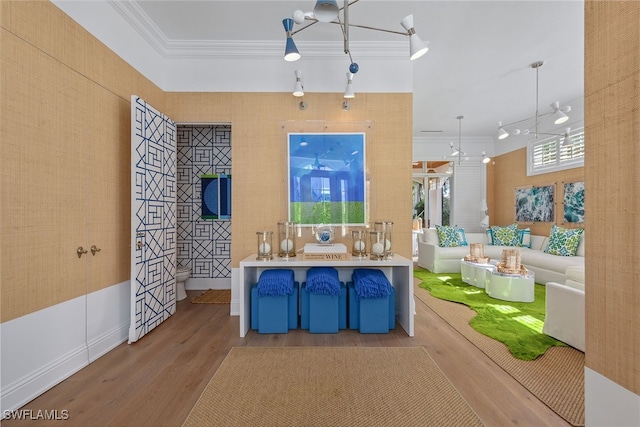 kitchen with hanging light fixtures, light hardwood / wood-style floors, and ornamental molding