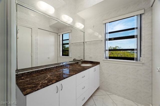 bathroom featuring vanity, tile walls, and a healthy amount of sunlight