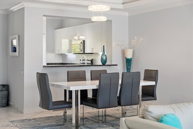 dining room featuring an inviting chandelier, crown molding, and sink