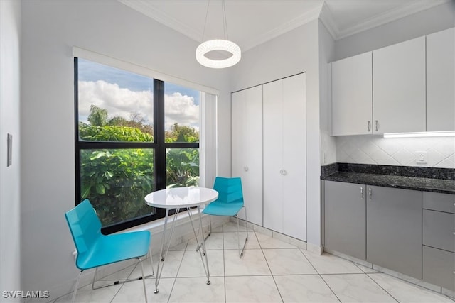 dining space with crown molding and light tile patterned floors