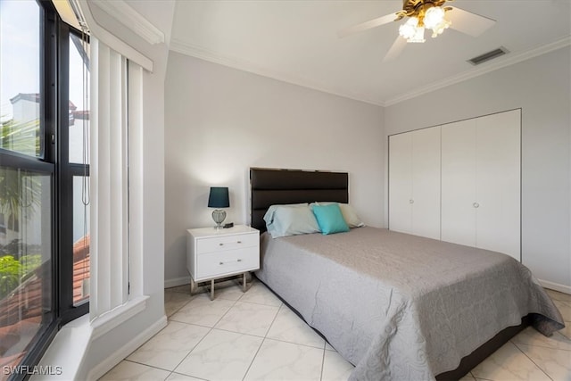 bedroom featuring ceiling fan, crown molding, and a closet