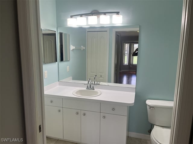 bathroom with tile patterned flooring, vanity, and toilet