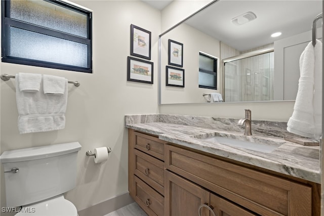 bathroom with vanity, toilet, and a shower with shower door