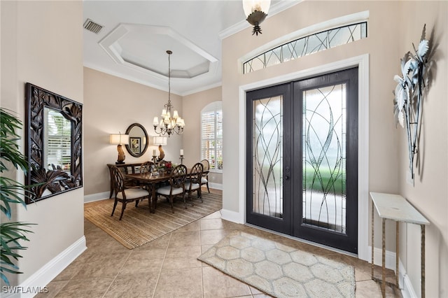 entrance foyer featuring a chandelier, ornamental molding, light tile patterned floors, and french doors