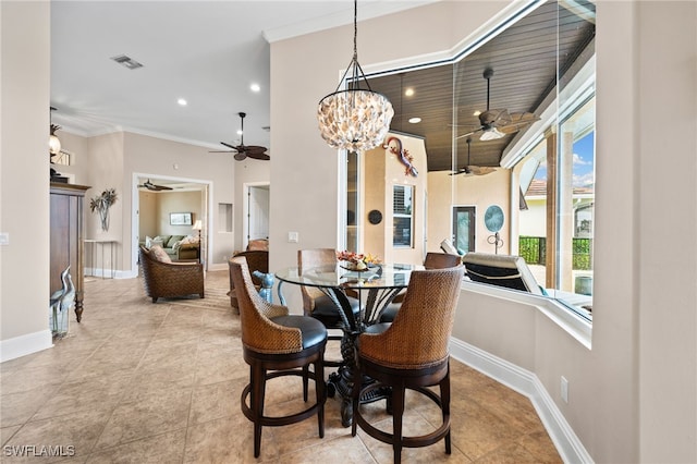 tiled dining space featuring ornamental molding and a chandelier