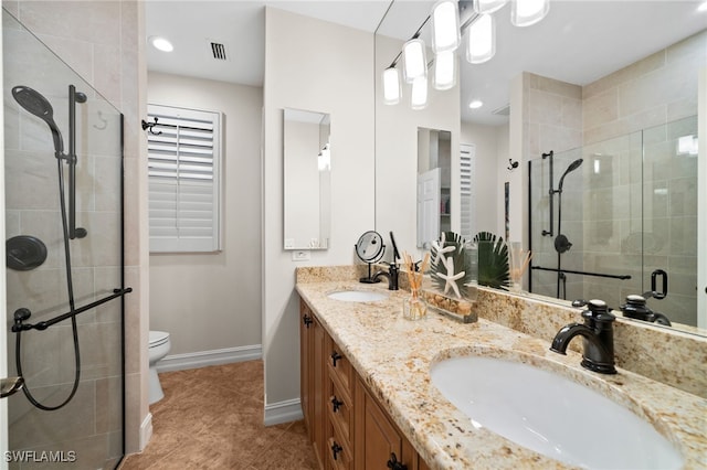 bathroom with tile patterned floors, vanity, toilet, and a shower with shower door