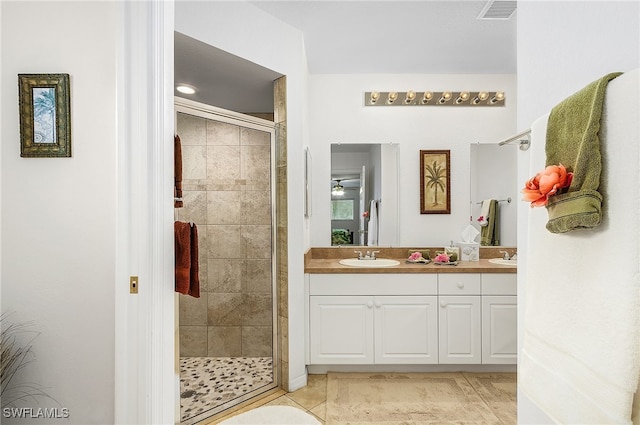 bathroom with vanity, a shower with door, and tile patterned floors