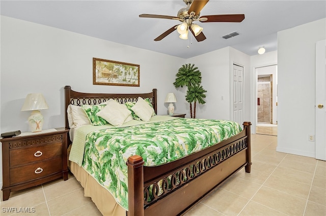 tiled bedroom featuring ensuite bathroom, ceiling fan, and a closet