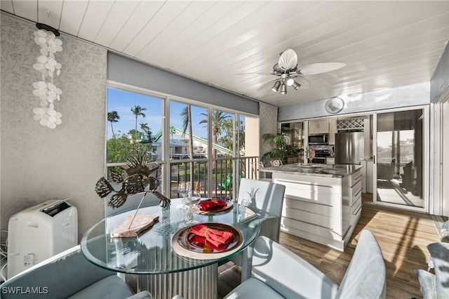 sunroom / solarium featuring wooden ceiling and ceiling fan