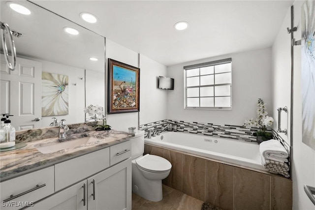 bathroom with vanity, tiled bath, and toilet