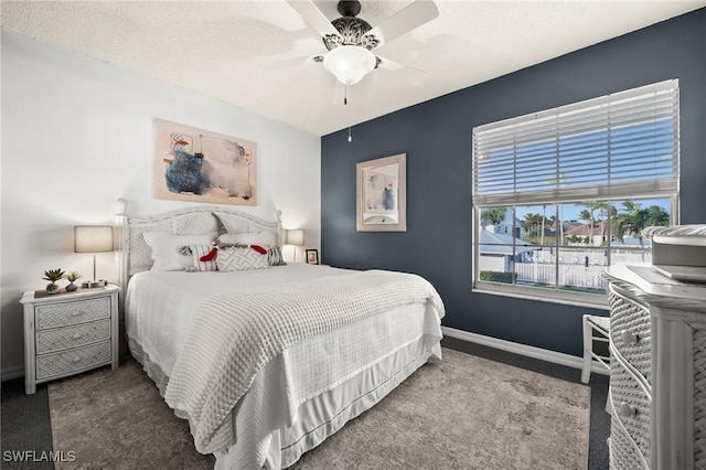 carpeted bedroom featuring a textured ceiling and ceiling fan