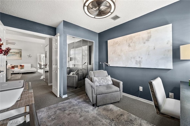 home office featuring dark colored carpet and a textured ceiling