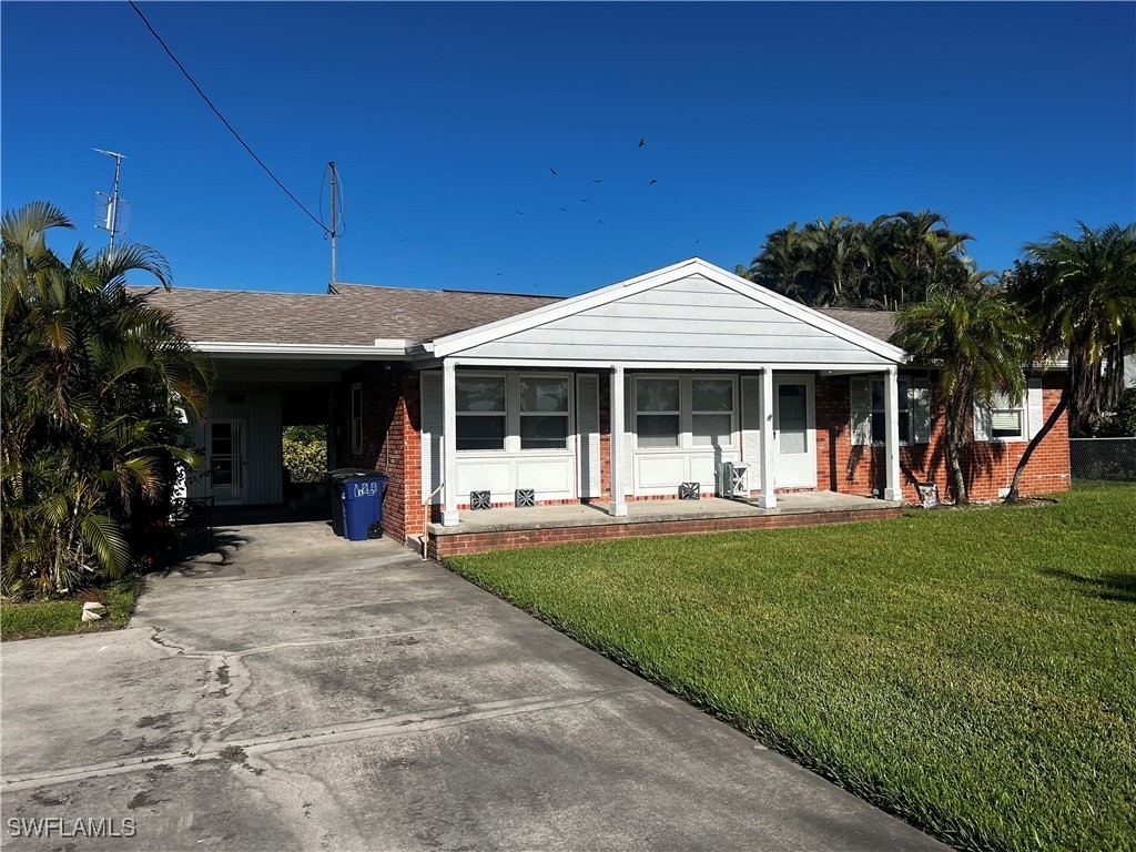 ranch-style home with a front yard and a carport