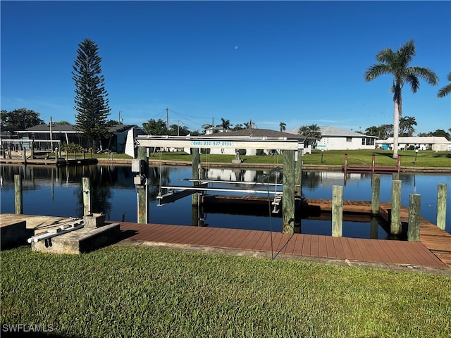 view of dock with a lawn and a water view