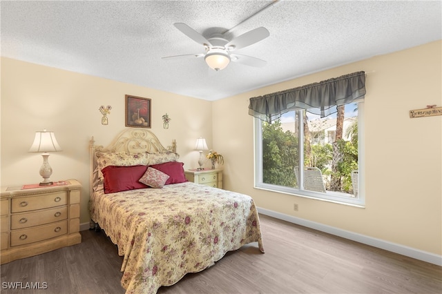 bedroom featuring hardwood / wood-style floors, ceiling fan, and a textured ceiling