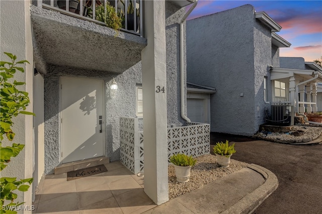 exterior entry at dusk featuring cooling unit