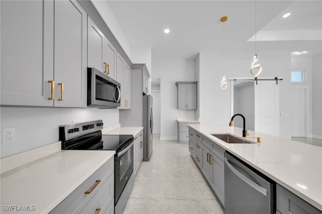 kitchen featuring hanging light fixtures, sink, gray cabinets, light stone countertops, and appliances with stainless steel finishes