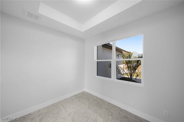 unfurnished room featuring a raised ceiling