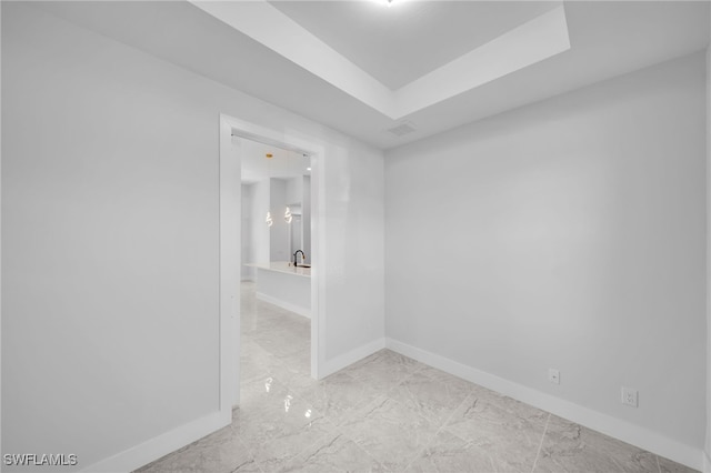 spare room featuring a raised ceiling