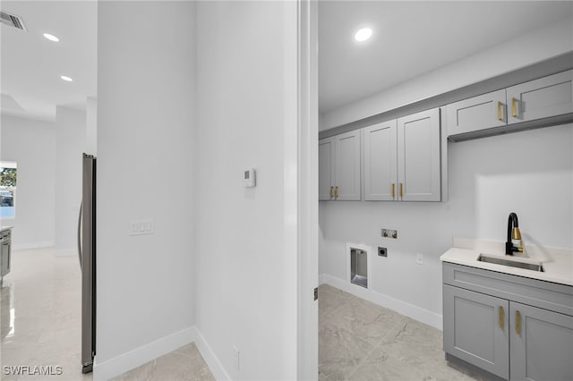 washroom featuring washer hookup, sink, cabinets, and hookup for an electric dryer