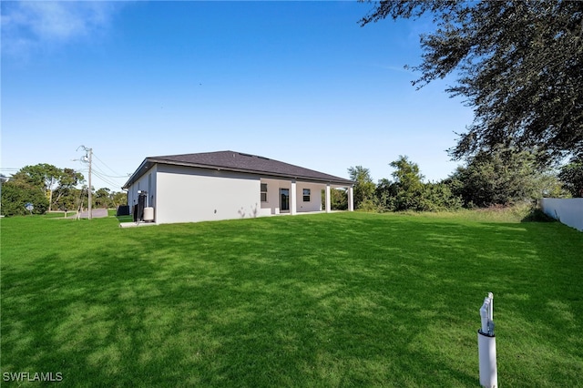 rear view of property featuring a yard