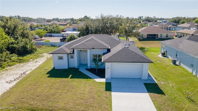 view of front of house with cooling unit, a front yard, and a garage