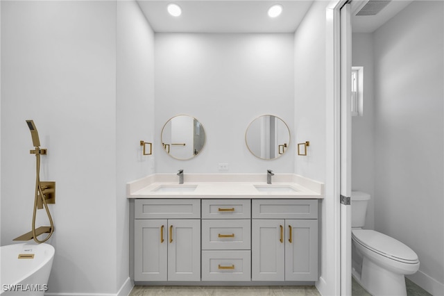 bathroom with vanity, toilet, and a washtub