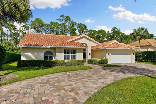 mediterranean / spanish house with a front lawn and a garage