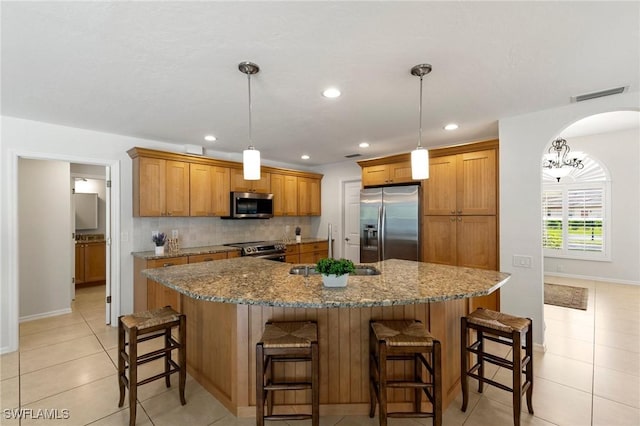 kitchen featuring tasteful backsplash, a large island, stainless steel appliances, decorative light fixtures, and sink