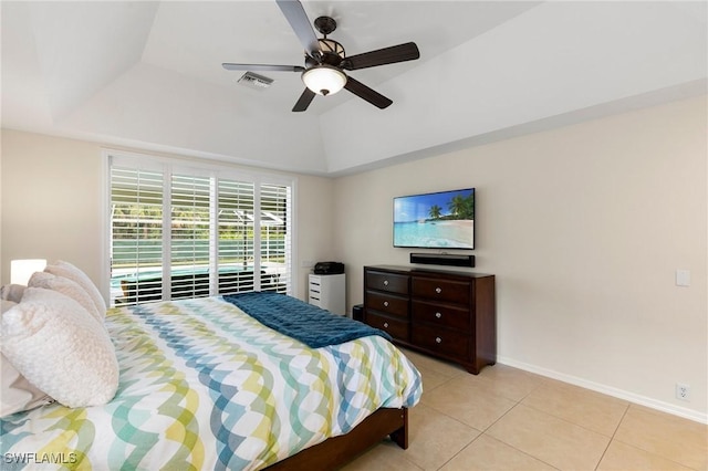 tiled bedroom with ceiling fan and a tray ceiling