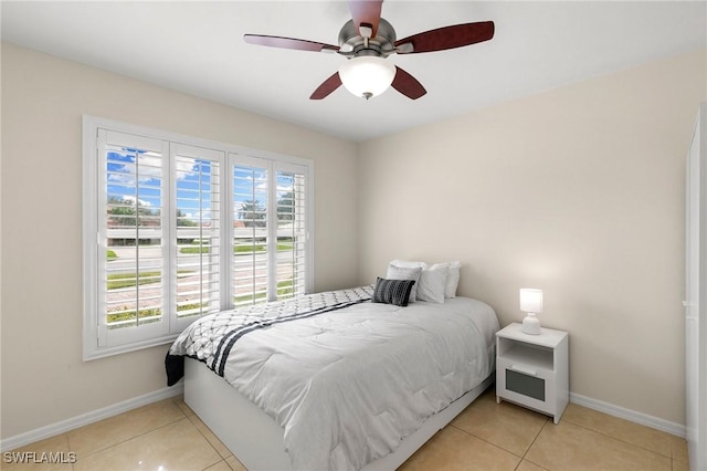 tiled bedroom featuring ceiling fan