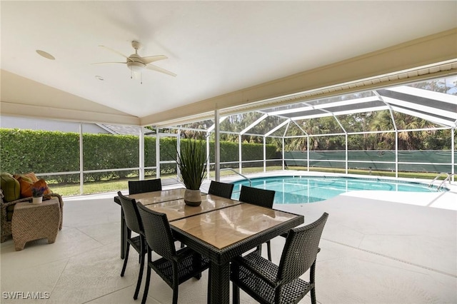 view of swimming pool with ceiling fan, glass enclosure, and a patio area