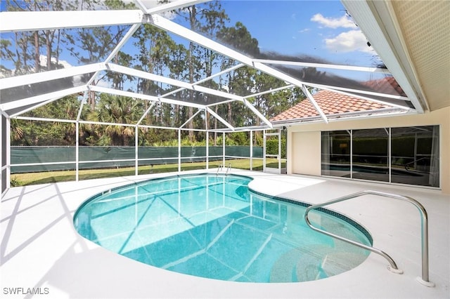 view of swimming pool featuring a patio area and glass enclosure