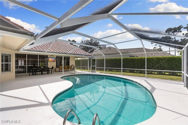 view of swimming pool with a lanai and a patio area