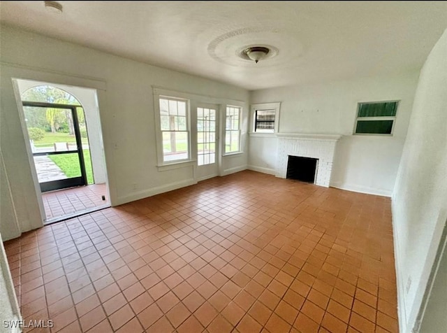 unfurnished living room with a brick fireplace