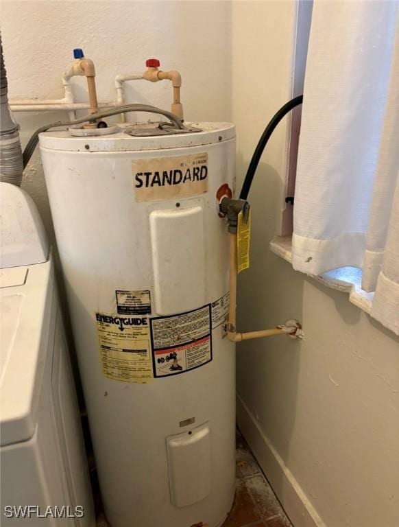 utility room with electric water heater and washer / dryer