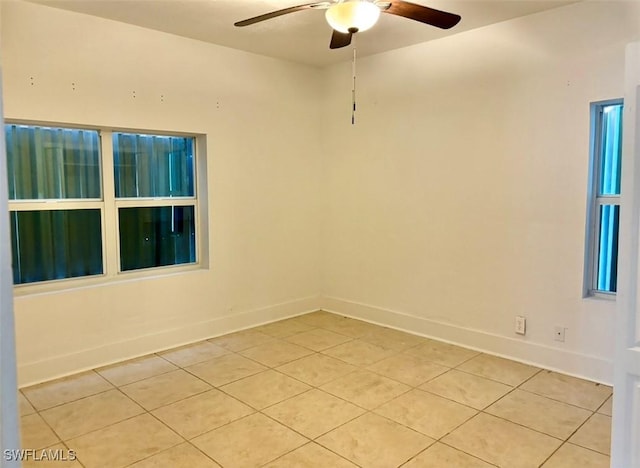 spare room with ceiling fan and light tile patterned flooring