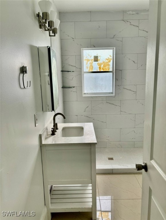 bathroom featuring tiled shower and vanity