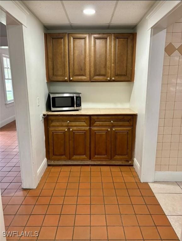 kitchen featuring a paneled ceiling and light tile patterned floors